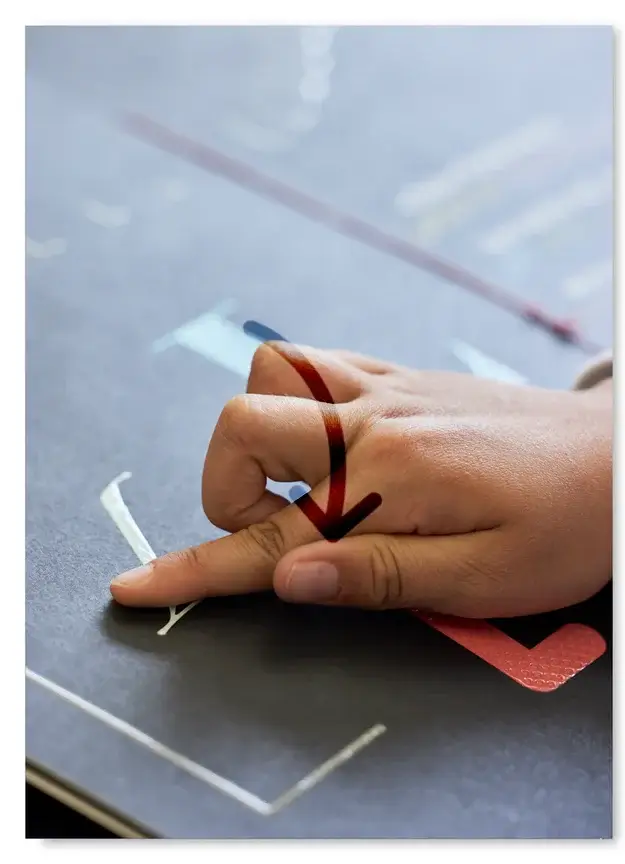 Hand, die Blindenschrift liest, und Grafik eines nach unten zeigenden Pfeils